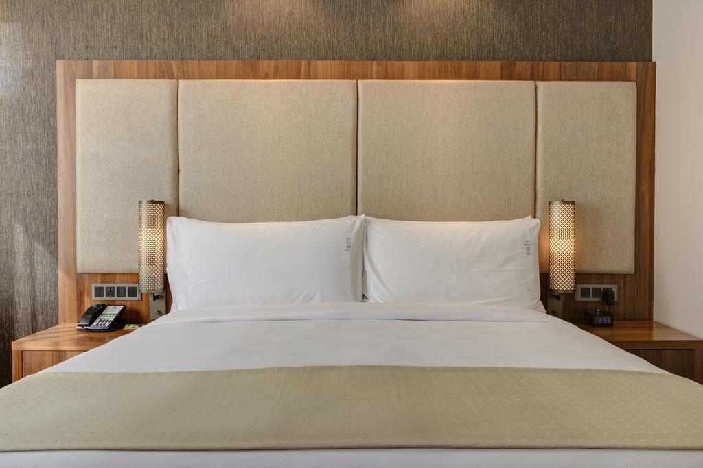 Holiday Inn Kolkata Airport By Ihg Esterno foto A bed with a headboard